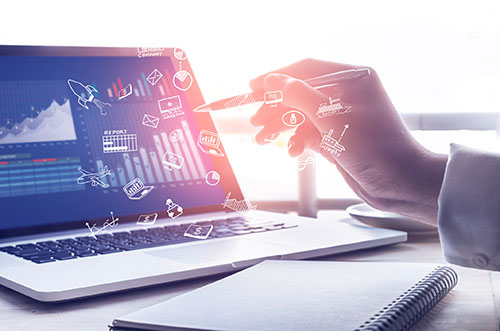 Person looking over charts and graphs with computer