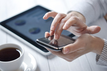 Image of a person using a tablet and smartphone