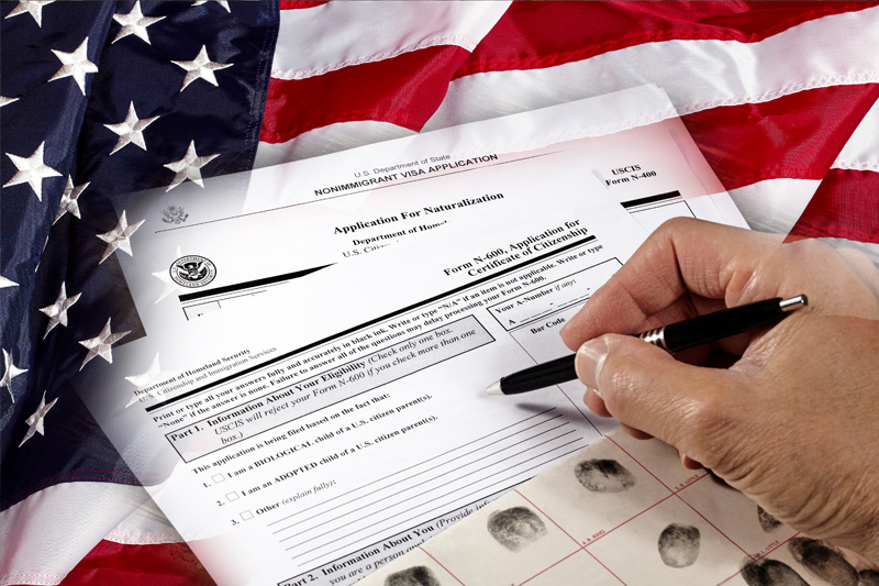 Signing on Immigration paperwork overlayed by the American Flag